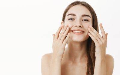 encantadora-jovem-relaxada-e-gentil-fazendo-procedimento-cosmetologico-aplicando-creme-facial-no-rosto-com-os-dedos-e-sorrindo-amplamente-sentindo-se-perfeita-cuidando-da-pele Bichectomia
